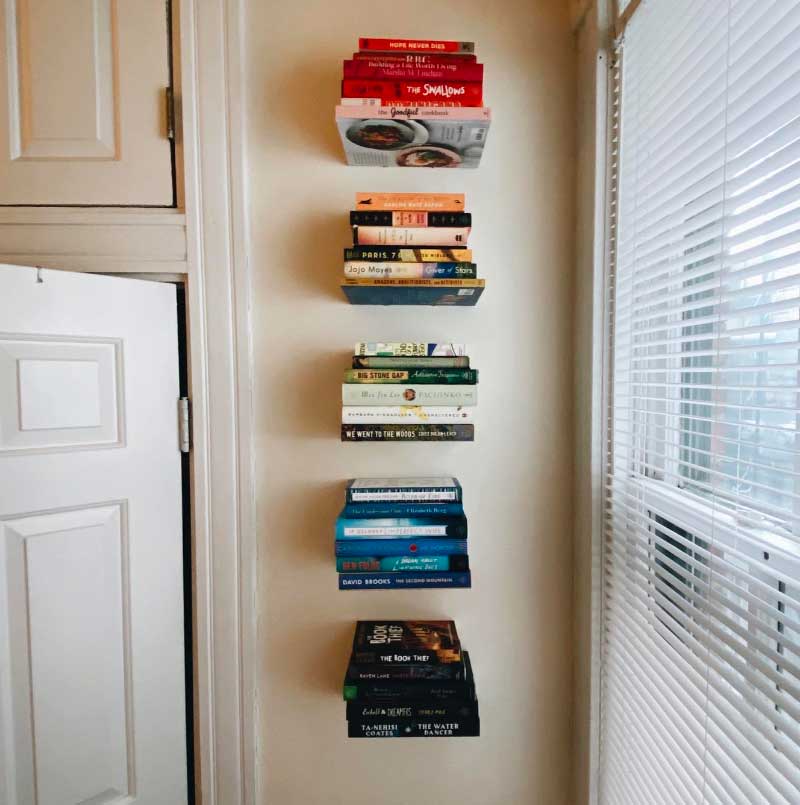 A row of books on a windowsill next to a window, representing the love of reading and the power of knowledge.