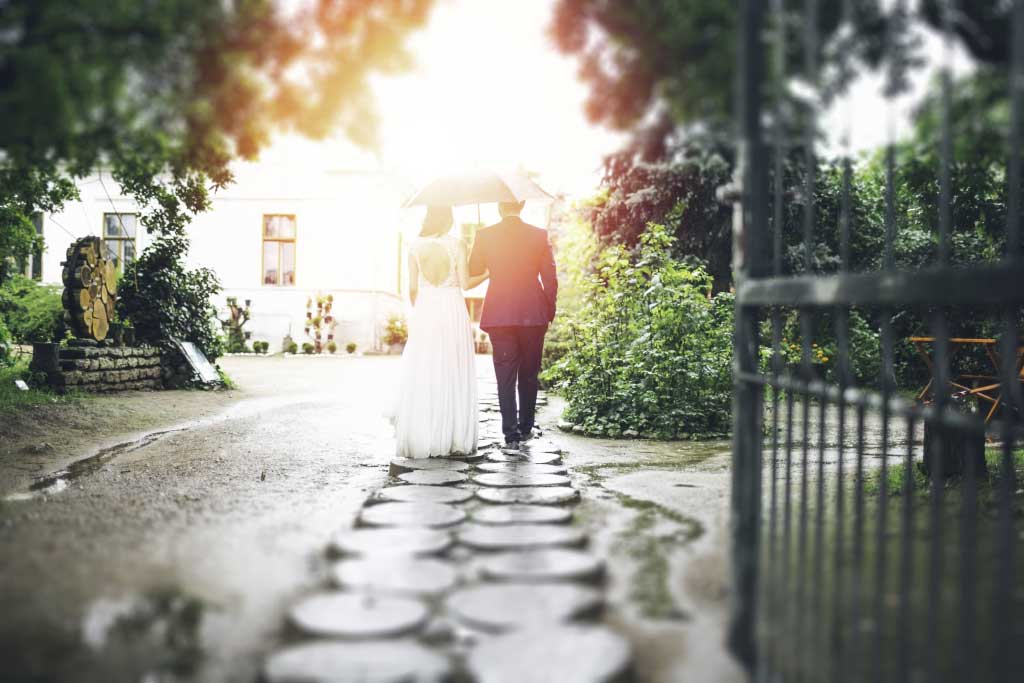 a man and woman walking down a path with an umbrella